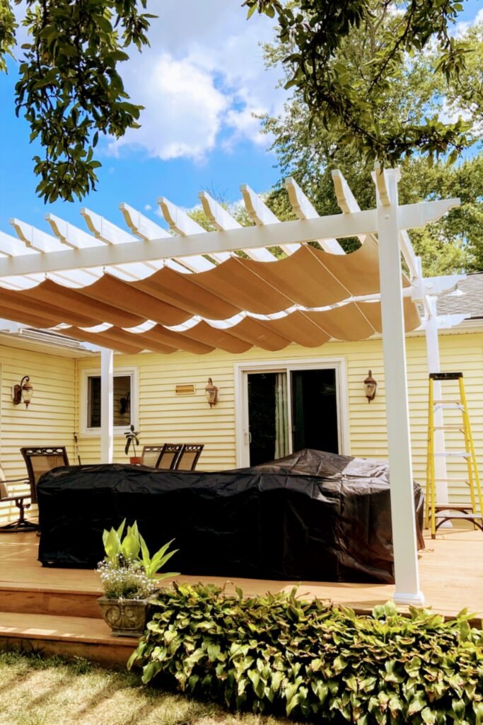 Under-pergola cable shade system with beige fabric installed in a Dallas backyard for sun protection.