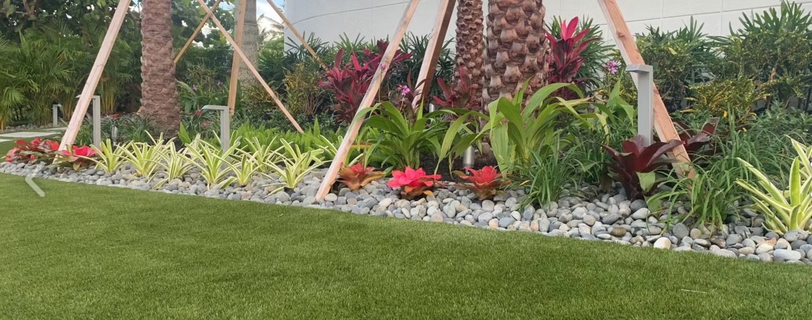 Artificial turf lawn beside a tropical planting bed