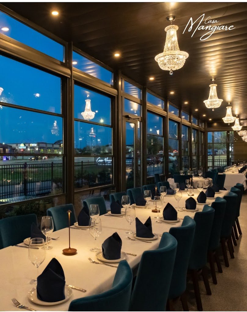 Interior of the glass-enclosed dining room with chandeliers and set tables