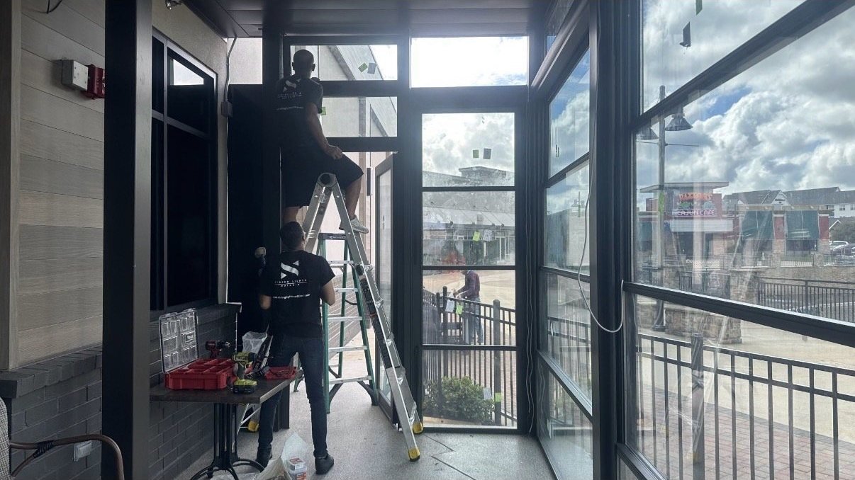 String Lights Outdoor installers fitting glass panels and the entry door