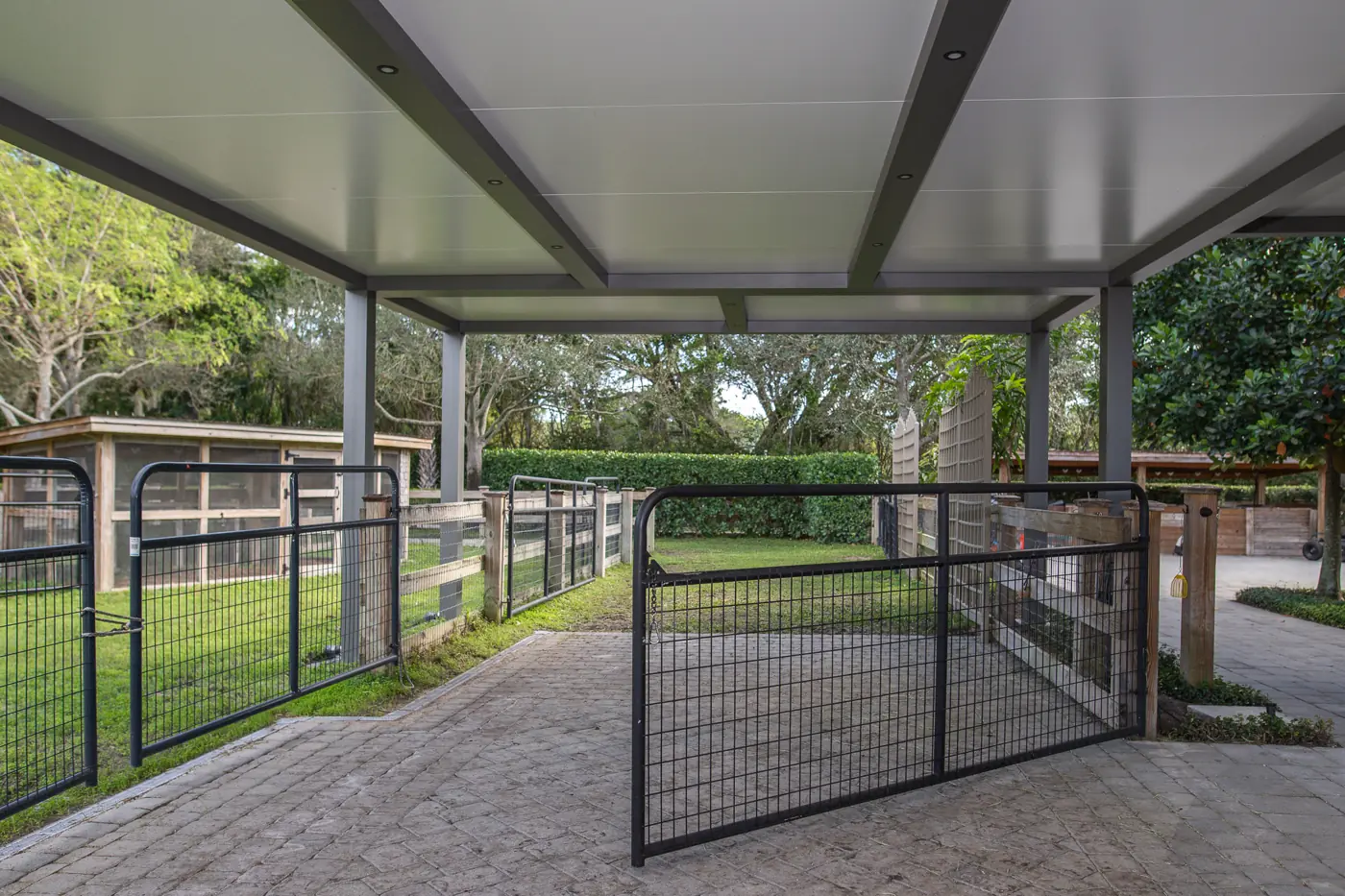 Insulated aluminum carport cover with dark gray frame and recessed lighting