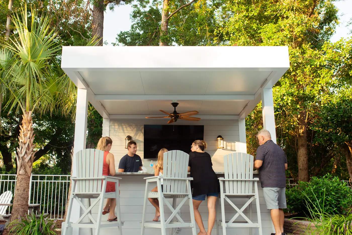 White insulated roof cover over an outdoor bar cabana with ceiling fan