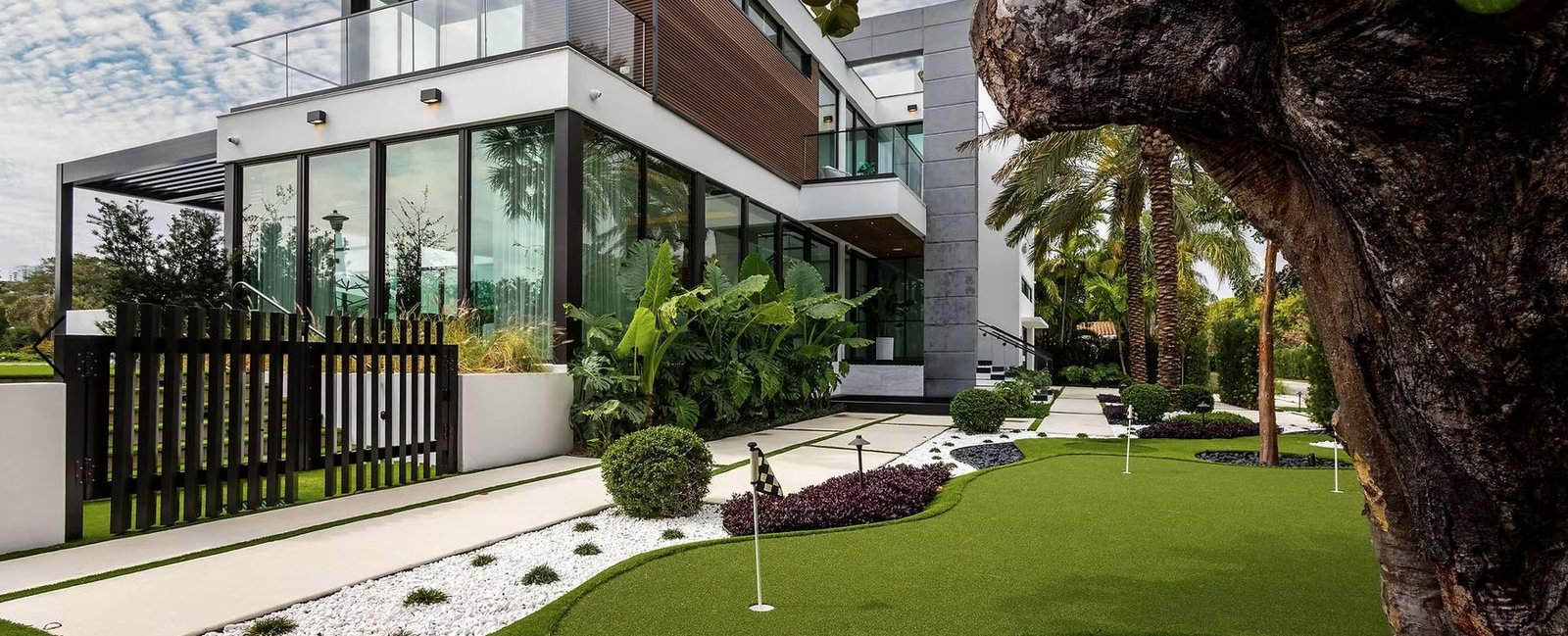 Modern home with artificial-turf putting green and white rock garden